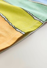 Multifarebný textil s horizontálnymi pruhmi v oranžovej, žltej, zelenej a modrej farbe. Mäkká textúra s kontrastnými švami.