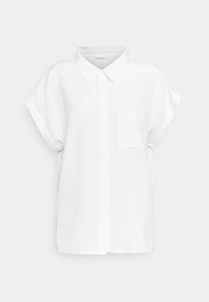 Camisa blanca de manga corta con botones, cuello y bolsillo en el pecho sobre un fondo claro y liso.
