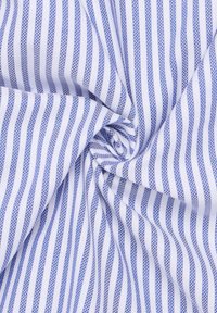 Katoenen stof in het wit met blauwe verticale strepen, met een gladde textuur. De stof is geplooid en toont zijn buigzaamheid en patroon.