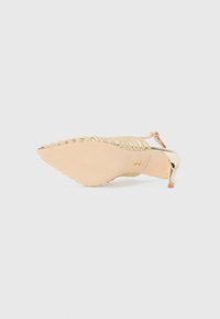 Scarpa con tacco alto dorata, con punta affusolata e accentuazioni metalliche. Presenta una fascia superiore intrecciata, un tacco sottile e una suola liscia.