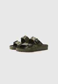 Olive green sandals with two adjustable straps, black hardware, textured soles, open toe, and sturdy construction.