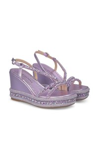 Sandales en wedge violettes avec un dessus brillant, des strap embellis et un détail en perles autour de la semelle. Design ouvert au bout avec des straps à la cheville.