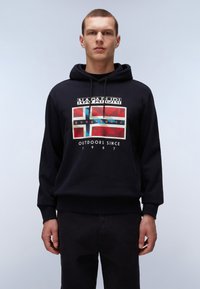 Sudadera negra con un gráfico frontal que presenta un diseño en azul y rojo, etiquetado "NAPAPIJRI geographics" y "OUTDOORS SINCE 1987". Textura suave.