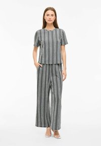 Striped matching set in gray and white, short-sleeve top with round neckline and loose-fitting pants. Lightweight fabric, casual design.
