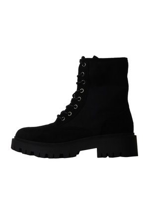 Bottine noire à lacets avec semelle épaisse et œillets métalliques, conçue pour un usage extérieur robuste ou décontracté.