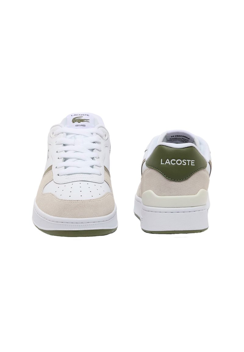 Lacoste-sneakers har en hvid overdel i læder med beigefarvede ruskindsdetaljer, grøn hælkappe og perforeret tå for åndbarhed. Tykk gummisål.