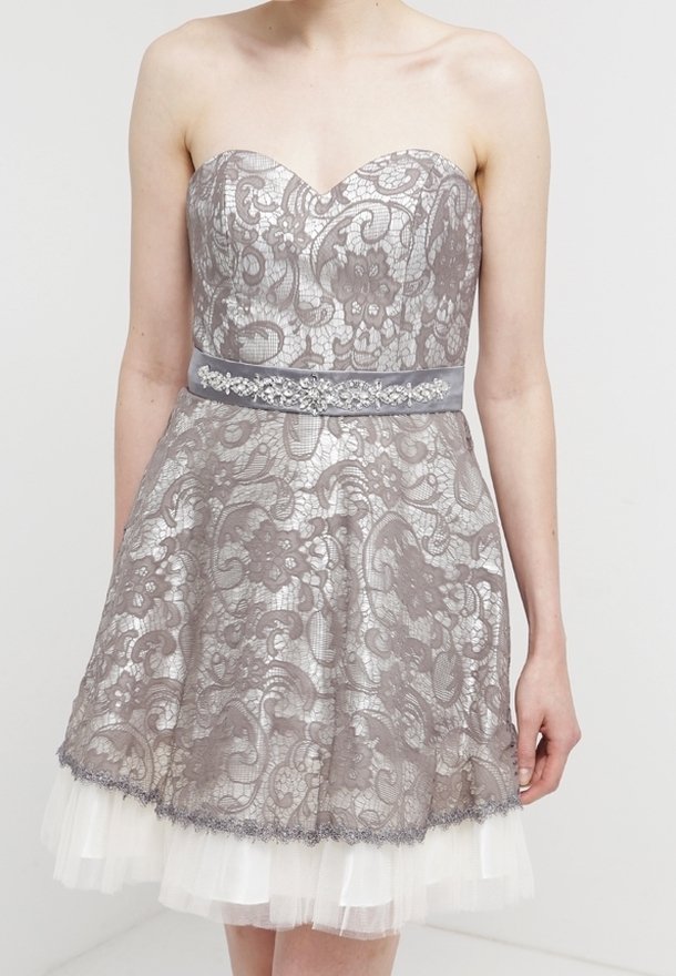 Robe bustier avec une superposition de dentelle argentée ornée de motifs floraux complexes, dotée d'une ceinture en satin gris clair avec des détails embellis et d'une jupe en tulle à plusieurs couches.