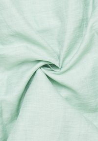 Lyst grønt stof med en blød, tekstureret overflade, præsenteret i en vredet opstilling, der viser dets lette og luftige egenskaber.