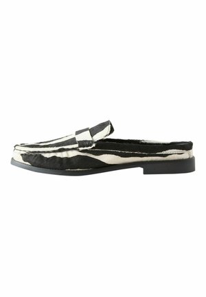 Zwart-witte slip-on muil met zebraprint, een platte zool en een band over het bovenste deel.