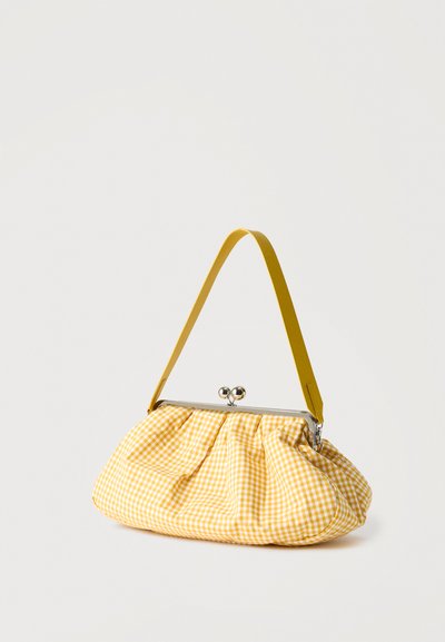 Sac en tissu vichy jaune et blanc avec fermoir argenté et large bandoulière jaune sur fond uni.