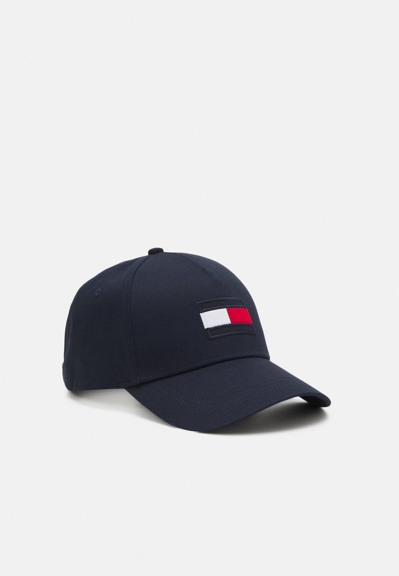 Casquette de baseball bleu marine avec un logo rectangulaire rouge, blanc et bleu sur le devant, posée sur un fond blanc uni.
