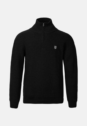 Melna adīta džemperis ar augstu apkakli un ceturtdaļas rāvējslēdzēju, kura virspusē ir ribota tekstūra un mazs emblema kreisajā krūtīs.