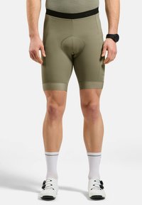 Olijfgroene fietsshorts met een strakke pasvorm, naadloze tailleband en een gevoerd zitgedeelte, met textuur aan de beenopeningen.
