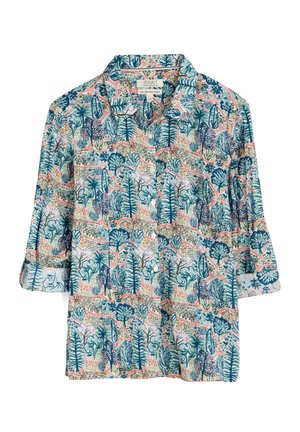 Camicia con bottoni e maniche lunghe, con una fantasia colorata a tema natura che ricopre l'intera superficie con alberi e piante in tonalità di blu, verde, rosa e beige.