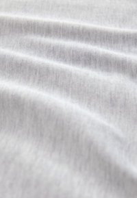 Helehall kangas, millel on sile tekstuur ja nähtavad venitusmärgid, ning peene heletriibulise mustriga üle kogu pinna.