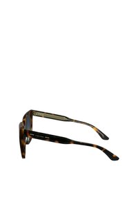Occhiali da sole tartaruga marrone con lenti quadrate, dettagli in oro sulle tempie e una superficie liscia e lucida. Marchio Calvin Klein sul lato.