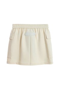 Minifalda de color crema con cintura elástica y dos bolsillos laterales con solapa, mostrada sobre un fondo blanco.