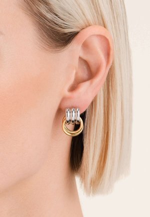 Pendientes de aro de plata con tres bandas apiladas y un acento circular dorado. Acabado de metal suave, que muestra un diseño moderno.