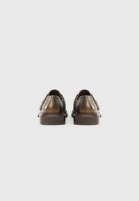 Brown leather shoes with a smooth finish, rounded toe, and thick soles. Features decorative stitching along the back and sides.