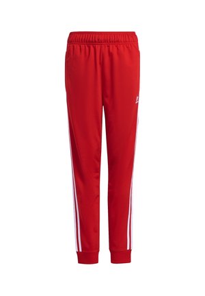 Pantalon de sport rouge avec taille élastique, bandes blanches latérales, poignets côtelés et petit logo blanc Adidas sur la partie supérieure de la cuisse.