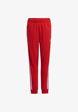 Pantalones deportivos rojos con cintura elástica, franjas laterales blancas, puños acanalados y un pequeño logo blanco de Adidas en la parte superior del muslo.