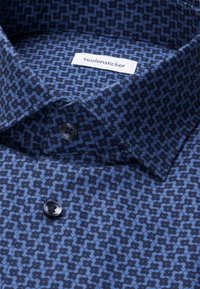 Chemise habillée bleue à motifs avec des boutons bleu foncé et une étiquette "seidensticker" visible à l'intérieur du col.