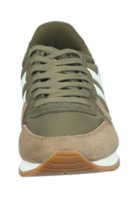 Baskets athlétiques vertes et beiges avec des matériaux en daim et en tissu, présentant des lacets, trois rayures blanches et une semelle en caoutchouc texturé.