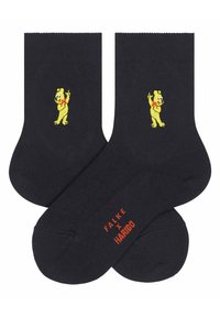 Schwarze Baumwollsocken mit gelber Bärenstickerei und rotem Logo-Text an der Sohle, die eine glatte Textur und ein knöchellanges Design aufweisen.