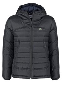 Veste noire matelassée avec capuche, fermeture éclair frontale, deux poches latérales zippées, et petit logo crocodile vert sur le côté gauche de la poitrine.