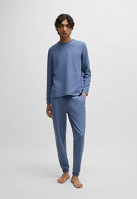 Blauw wafelkatoenen loungewear-set met een langemouwtop met een ronde hals en bijpassende broek met een elastische tailleband. Geen zichtbare branding.