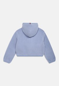 Modrá skrátená mikina z fleecu s textúrovaným povrchom, s pripojenou kapucňou a kontrastným horizontálnym prúžkom okolo krku. Hladké elastické manžety.