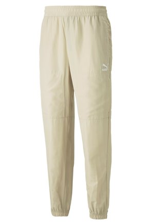 Helle beigefarbene Sporthose aus glattem, leichtem Stoff. Mit elastischem Bund und weißem Logo nahe der linken Hüfte. Mit schmal zulaufendem Bein und elastischen Bündchen.