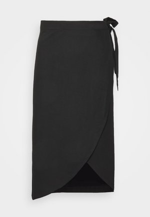 Jupe portefeuille noire avec fermeture nouée sur le côté et ourlet asymétrique superposé, longueur au genou, tissu lisse, présentée à plat sur fond blanc.