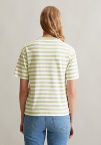 T-shirt en coton rayé vert et blanc à manches courtes et encolure ronde, avec une coupe décontractée et un ourlet droit.