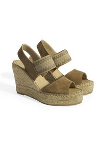 Sandales compensées en suède marron avec orteils ouverts, brides réglables et détail en jute tressé sur la semelle. La texture est douce avec une construction robuste.