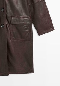 Bordeaux leren jas met een zachte textuur, twee grote voorzakken, knoopsluitingen en een losse pasvorm.