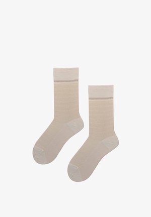 Paar beige Crew-Socken mit einem etwas dunkleren Bündchen und verstärkten Zehen- und Fersenbereichen auf weißem Hintergrund.