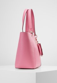 Sac à main structuré rose avec une surface texturée, des poignées doubles et une petite pochette attachée avec des accents en matériel doré.