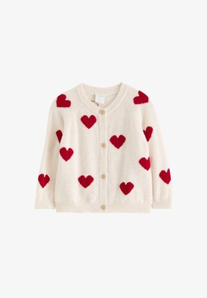 Flødefarvet cardigan med lange ærmer, træknapper og røde hjerte-mønstre spredt over stoffet.