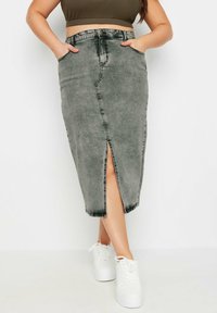 Harmaa farkkuhame, jossa on edessä halkio, korkea vyötärö ja taskut. Yhdistetty valkoisiin tennareihin, mikä luo rentoa katumuotia.