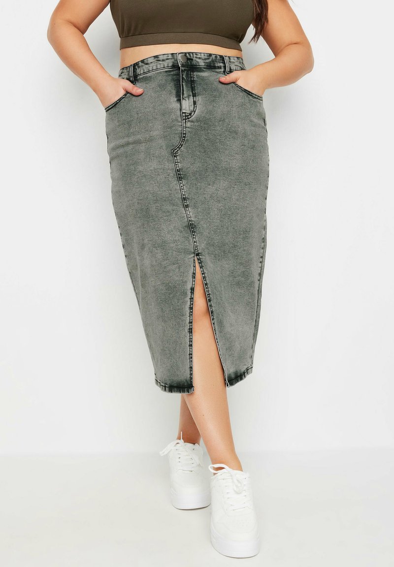 Harmaa farkkuhame, jossa on edessä halkio, korkea vyötärö ja taskut. Yhdistetty valkoisiin tennareihin, mikä luo rentoa katumuotia.