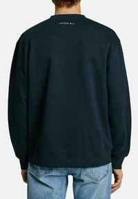 Dark blue sweatshirt with a crew neck, long sleeves, and ribbed cuffs. Features "LONDON W11" printed on the back near the neckline.