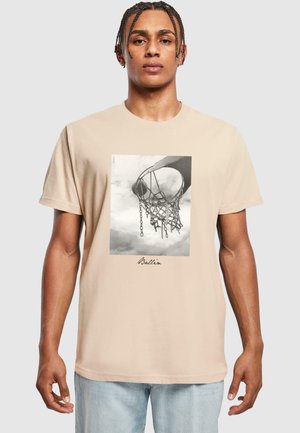 Kremų medvilnės marškiniai su juodai balta krepšinio krepšio grafika, o po vaizdu tekstas "Ballin'".