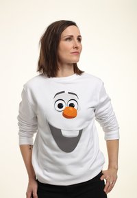 Weißer Sweatshirt mit einem großen grafischen Motiv eines lächelnden Schneemann-Gesichts mit einer orangefarbenen Karottennase und schwarzen Augen, aus weichem Stoff gefertigt.