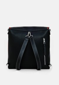 Sac à dos en simili cuir noir avec quincaillerie argentée, bretelles ajustables, poche zippée à l'avant et accent rouge en haut. Texture lisse et forme carrée.