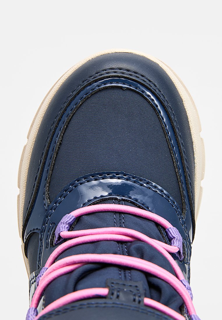 Marineblaue Sneaker mit glänzenden Akzenten, rosa Schnürsenkeln und beiger Sohle, aus der Vogelperspektive auf einem schlichten Hintergrund dargestellt.