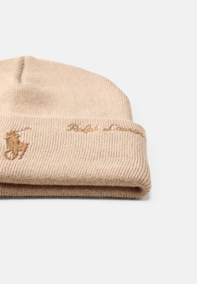 Gorro de malha bege com textura canelada, apresentando um logótipo bordado e nome da marca na mesma cor na dobra.