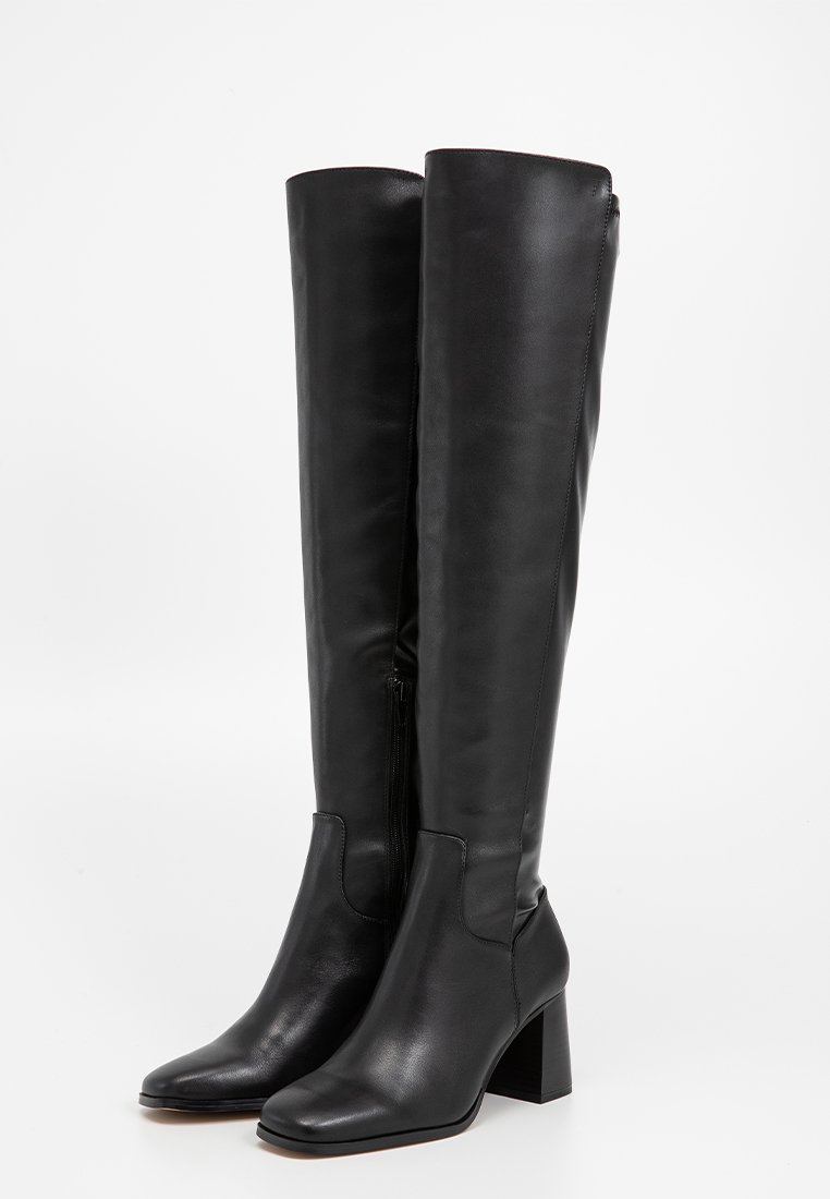 Stivali neri in pelle al ginocchio con una texture liscia, punta quadrata e tacco a blocco. Presentano una chiusura con zip laterale per una facile vestibilità.