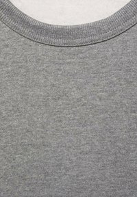 Pulover gri cu guler rotund, fabricat dintr-un material texturat. Dispune de un guler ribbit și o suprafață netedă. Simplu și de culoare uniformă, fără modele sau accente.