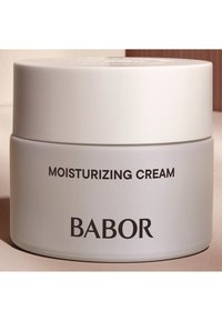 Pot rond blanc étiqueté "CRÈME HYDRATANTE" en caractères noirs, avec le logo "BABOR" bien en vue. Fini lisse et mat.